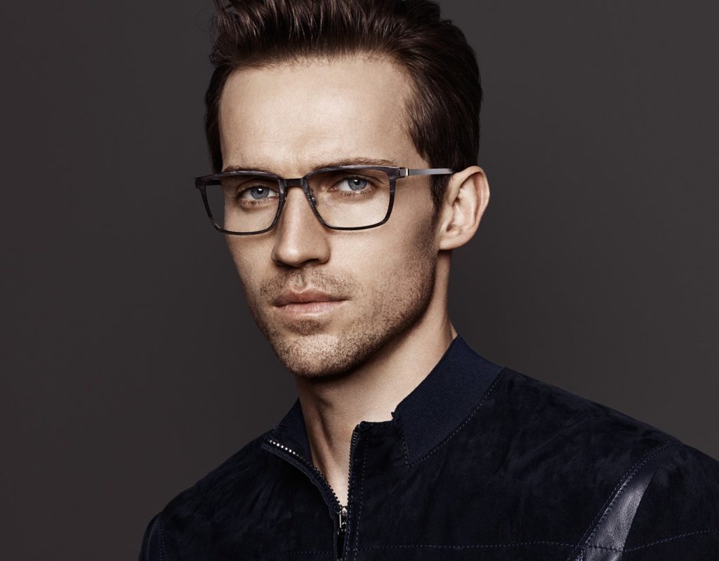 A man wearing designer eyeglasses staring straight into the camera