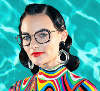 A woman in colorful clothes wearing designer eyeglasses