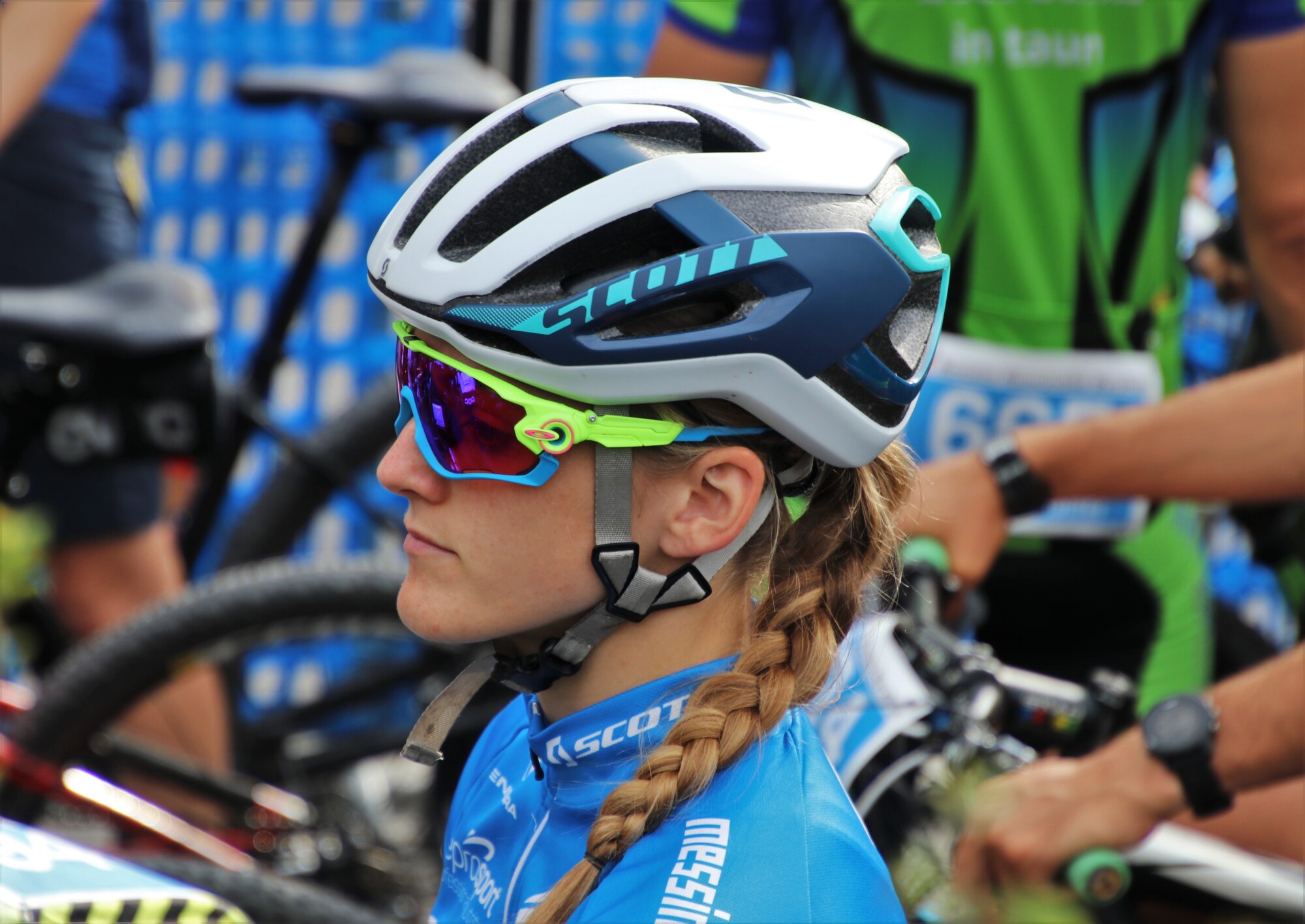 A woman cyclist wearing sports sunglasses while waiting for the marathon to start