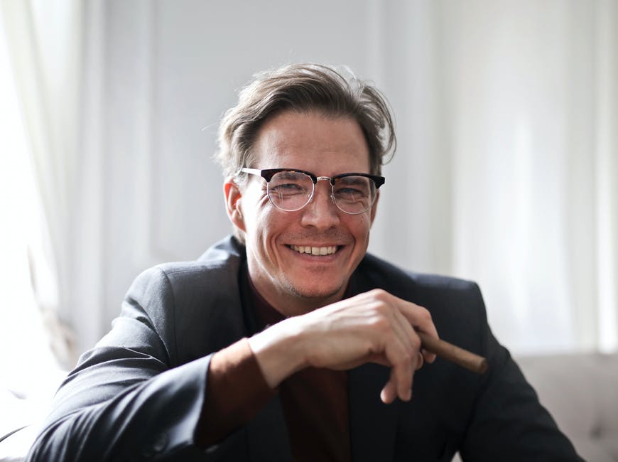 A smiling man wearing prescription glasses