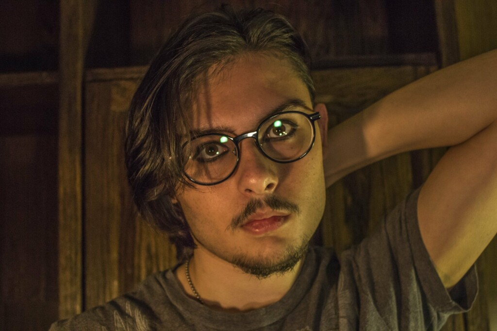 Man staring into a camera wearing eyeglasses