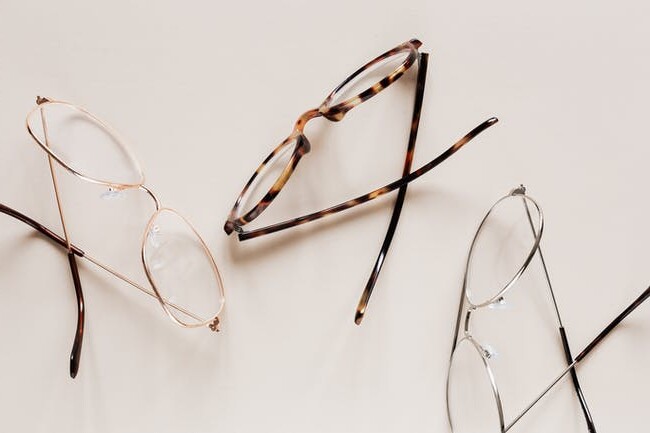 3 prescription glasses with different designs on top of a white surface