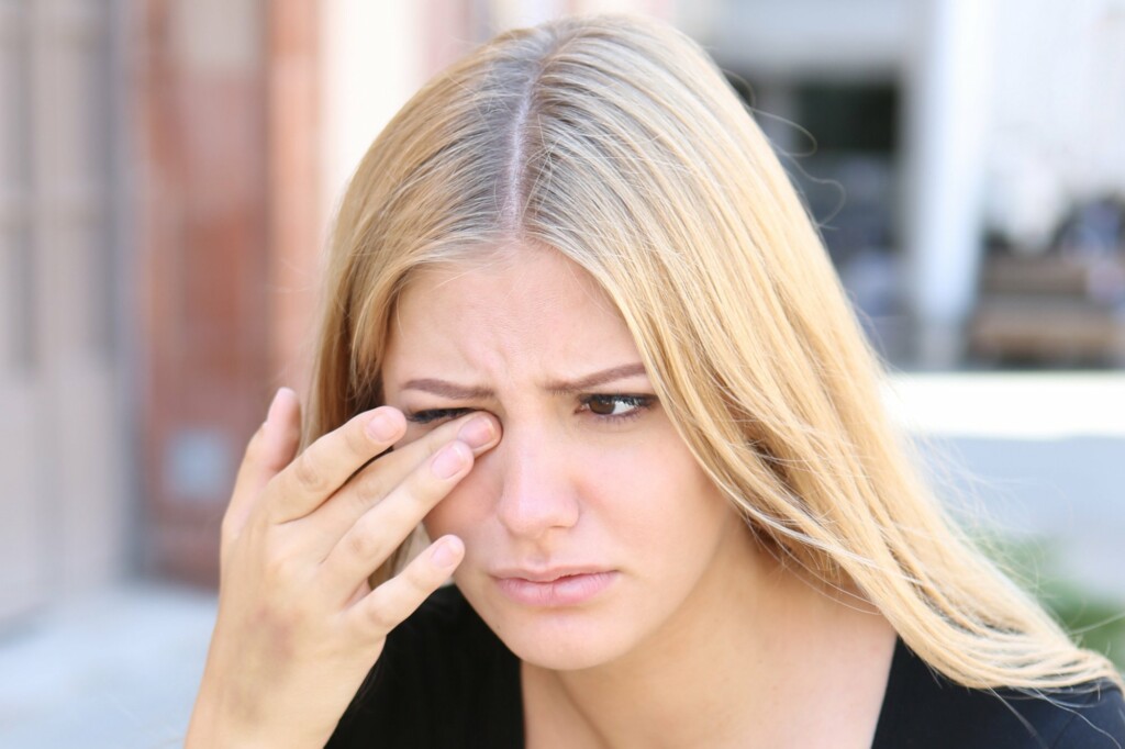 woman is touching her hurting eyes