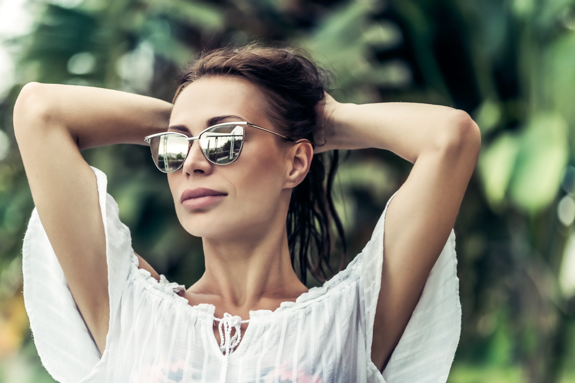 a woman in white blouse wearing designer sunglasses