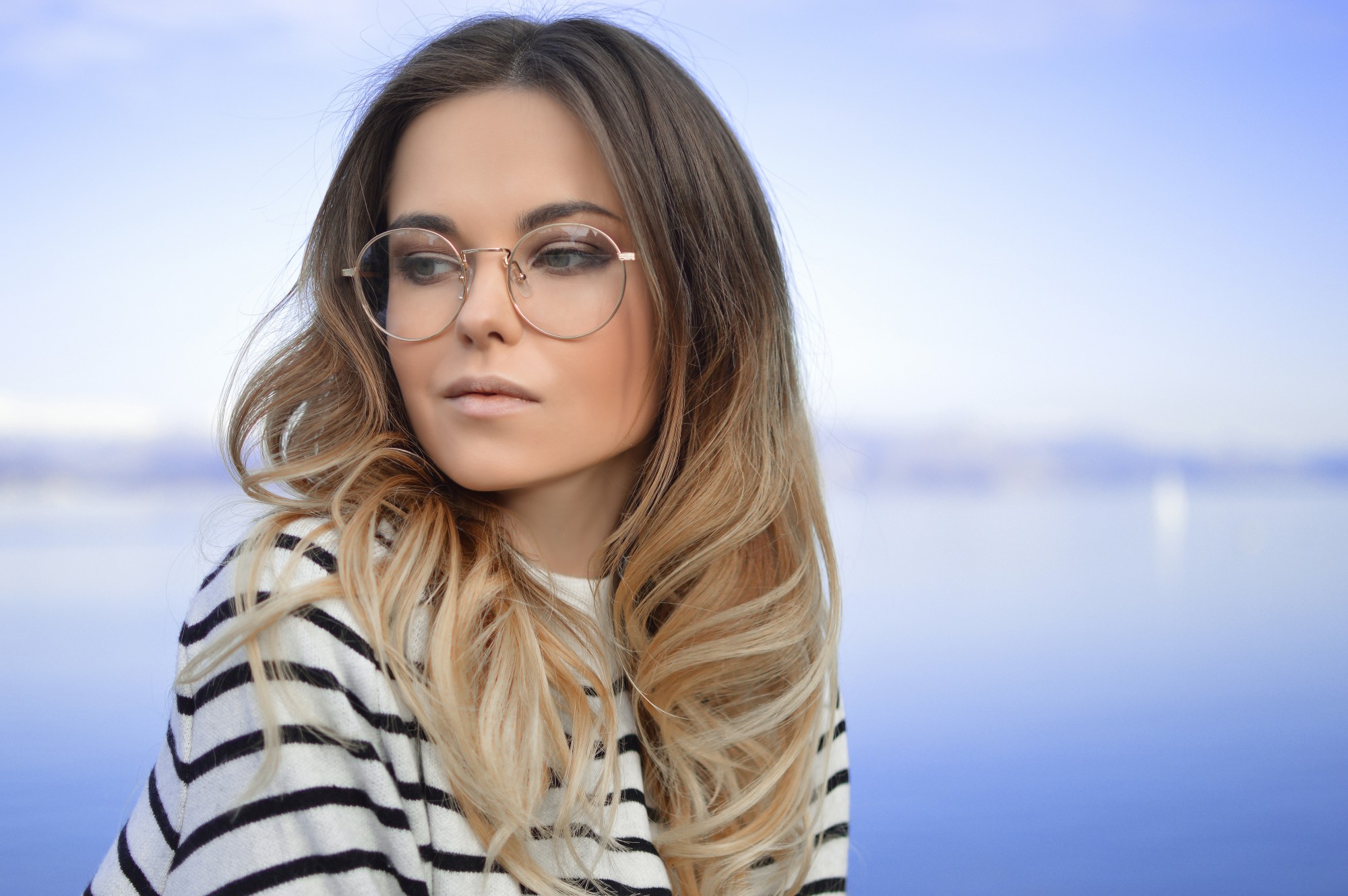 Woman wearing eyeglasses with a background of the sea