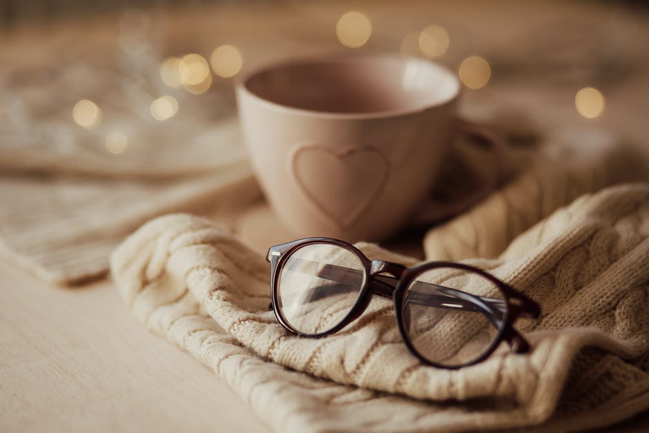 glasses beside a cup with a heart design