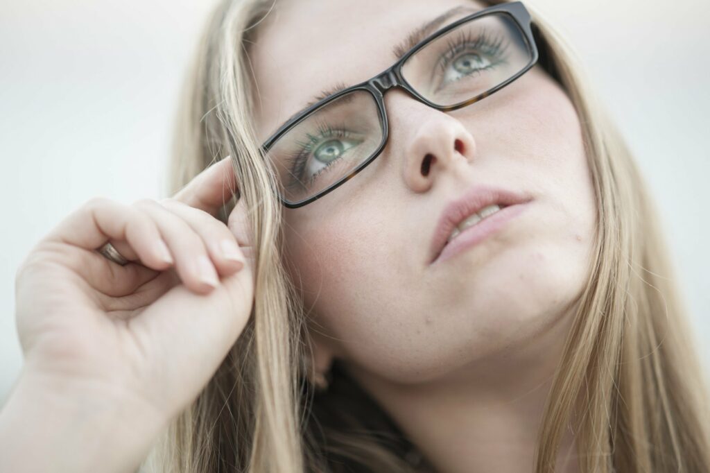 Woman looking at the sky holding on to her designer prescription glasses